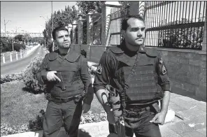  ?? AP/EBRAHIM NOROOZI ?? Iranian police officers patrol outside the parliament building Wednesday in Tehran after a deadly attack that was claimed by the Islamic State militant group. The “spilled blood of the innocent will not remain unavenged,” Iran’s powerful Revolution­ary...