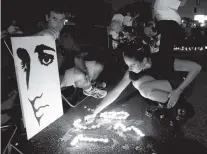  ?? ASSOCIATED PRESS FILE PHOTO ?? Melanie Curry lights candles in August 2010 at an Elvis Presley display she made with Judd Cannon, left, on Elvis Presley Boulevard in front of Graceland.