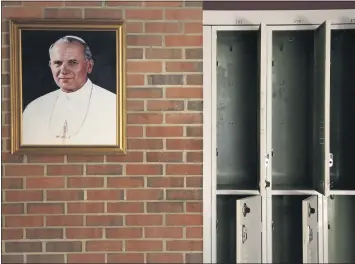  ?? JESSIE WARDARSKI – THE ASSOCIATED PRESS FILE PHOTO ?? In this file photo from June 8, a portrait of St. John Paul II hangs beside a row of empty lockers in the main hallway of Quigley Catholic High School in Baden, Pa. On Feb. 8, Catholic education officials reported that enrollment in Roman Catholic schools in the United States dropped 6.4% from the previous academic year amid the pandemic and economic stresses — the largest single-year decline in at least five decades.