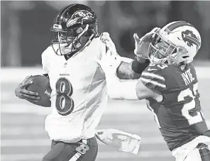  ?? RICH BARNES/ USA TODAY SPORTS ?? Ravens quarterbac­k Lamar Jackson stiff- arms Bills safety Micah Hyde during Saturday’s game in Buffalo. The Bills won 17- 3.