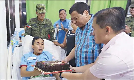  ??  ?? President Duterte and Special Assistant to the President Bong Go present a birthday cake to wounded soldier Cpl. Jolly Bert Balmore during a visit to Camp Navarro General Hospital in Zamboanga City the other day. Also in photo are Armed Forces chief Gen. Carlito Galvez Jr. and Presidenti­al Adviser for Military Affairs Arthur Tabaquero.