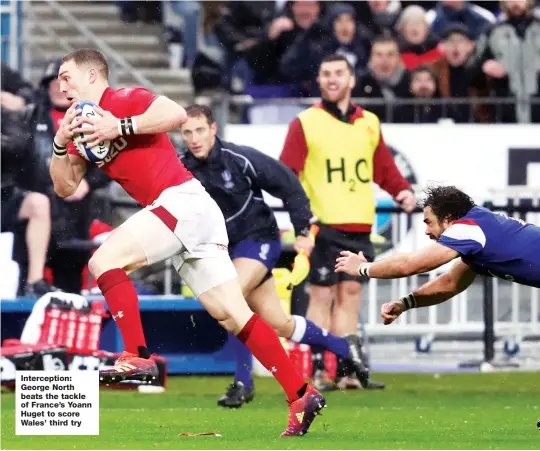  ??  ?? Intercepti­on: George North beats the tackle of France’s Yoann Huget to score Wales’ third try