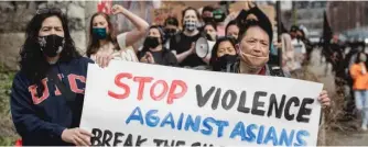  ??  ?? Ching Yung (right) marches with other activists on Saturday from Grant Park to Chinatown.