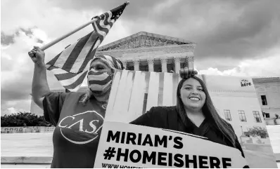  ?? AP ?? Ivania Castillo from Prince William County, Virginia, holds a banner to show her support for dreamer Miriam from California as she joins Deferred Action for Childhood Arrivals recipients celebrate in front of the US Supreme Court after the Supreme Court rejected President Donald Trump’s bid to end legal protection­s for young immigrants, yesterday, in Washington.