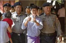  ?? THEIN ZAW / ASSOCIATED PRESS ?? Reuters journalist Wa Lone is escorted by Myanmar police upon arrival at the court for trial on the outskirts of Yangon, Myanmar, on Feb. 1.