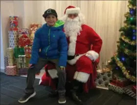 ?? GLENN GRIFFITH — DIGITAL FIRST MEDIA ?? Ryan Ayotte, 9, with Santa in downtown Troy on Saturday.