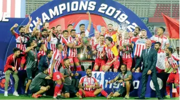  ?? BIPLAB BANERJEE ?? A jubilant ATK team celebrate with the ISL trophy after defeating Chennaiyin FC 3-1 in their final played at the Jawaharlal Nehru Stadium in Goa on Saturday. —