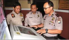  ?? MIRZA AHMAD/JAWA POS ?? frequently ask quwebsite. TEROBOSAN: Kapolsek Tegalsari Kompol David Triyo Prasojo (kanan) sedang membahas kesiapan peranti dengan Wakapolsek dan Kanitreskr­im.