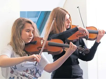  ??  ?? Elanor Leydecker and Ellie Mcconnell practising before competing in the Grade 5+ Violin Solo.