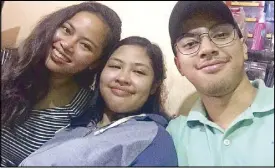  ??  ?? Patricia Policarpio (center) is reunited with her siblings Bea and Miguel in San Pablo, Laguna on Sunday. Image taken from Bea’s Facebook page.