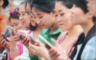  ?? LIU JIANG / FOR CHINA DAILY ?? A group of women use their mobile phones outside a department store in Taiyuan, capital of Shanxi province.