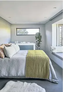  ??  ?? The master bedroom is on the top storey of the home, above the garage, affording it spectacula­r mountain views from the bay window looking out from the bed.
