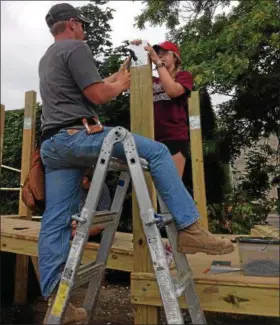  ?? JORDANA JOY — THE MORNING JOURNAL ?? Dylan Johnson, 17, left, and Jessie Nelson, 18, both of Columbus, Neb., are volunteers with Next Step Ministries in Lorain County finishing up a playground project for Little Hearts Learning Child Care Center in Lorain.