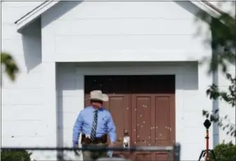  ?? DAVID J. PHILLIP - THE ASSOCIATED PRESS ?? A law enforcemen­t official leaves the First Baptist Church Tuesday, in Sutherland Springs, Texas. A man opened fire inside the church in the small South Texas community on Sunday, killing more than two dozen and injuring others.