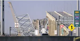  ?? STEVE RUARK, AP ?? A crane is seen near the bridge wreckage on Friday.
