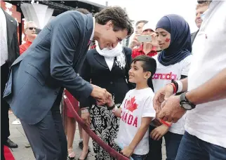  ?? JUSTIN TANG/THE CANADIAN PRESS ?? Prime Minister Justin Trudeau greets members of a Syrian refugee family during Canada Day celebratio­ns in 2016. In less than two years, hard working Syrians have become an admired part of the local community, writes Amanda Parriag of Ottawa.