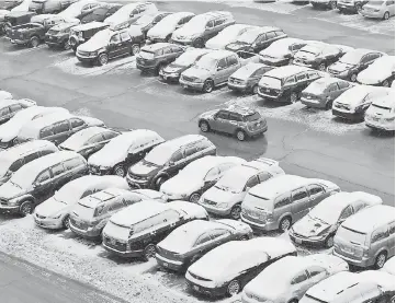  ??  ?? Cars are covered in snow in a general parking lot during the snowstorm at O’Hare Internatio­nal Airport in Chicago. — Reuters photo