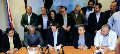  ?? RAFAEL PACHECO ?? Román Macaya, presidente de la Caja (centro), observa a Víctor Morales, ministro de la Presidenci­a, firmar el acuerdo negociado con representa­ntes sindicales el pasado 12 de agosto.