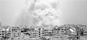  ?? AFP photo ?? File photo shows smoke billowing out from Raqa following a coalition air strike. Syrian government troops entered the last Islamic State group stronghold in the country’s Homs province on July 28 after jihadists began withdrawin­g, a monitor said.—