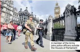  ??  ?? A member of the Army joins police officers outside the Houses of Parliament