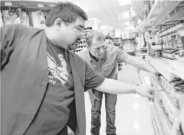  ?? Michael Short photos ?? TaskRabbit worker Brian Schrier, right, gets help from employee Maccewill Yip as he shops for supplies at a hardware store in Oakland. Workers for on-demand startups like TaskRabbit are almost uniformly independen­t contractor­s rather than salaried...