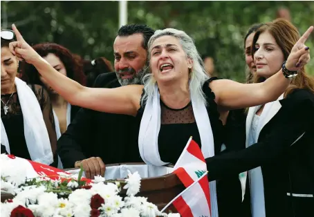  ?? AP ?? Lara, the wife of Alaa Abou Fakher who was killed during protest in Beirut, mourns over her husband’s body, in Choueifat city, Lebanon.