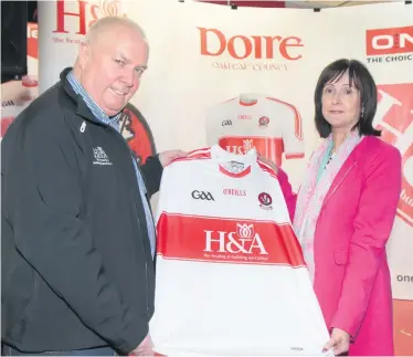  ??  ?? Hugh Mcwilliams and his wife Anne with a Derry GAA jersey featuring the H&A Mechanical Services logo