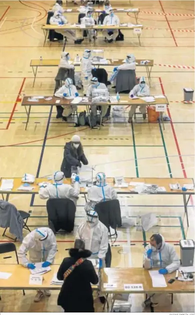  ?? QUIQUE GARCÍA / EFE ?? Varias personas con EPI trabajan ayer en las mesas en el Municipal de la España Industrial de Barcelona.