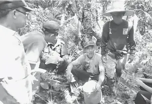  ??  ?? SESAT: Among (duduk, tengah) ditemui keletihan setelah hampir 24 jam hilang di hutan.