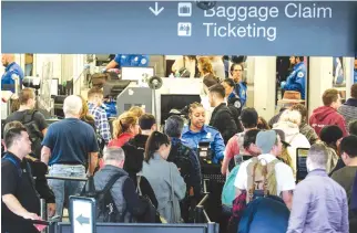  ??  ?? THIS file photo taken on Dec. 20, 2016 shows holiday travelers waiting in line to go through the security checkpoint at the Los Angeles Internatio­nal Airport, California. Worldwide passenger air traffic grew again last year, albeit at a slightly slower...