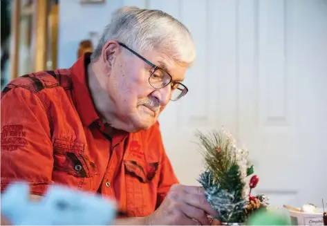  ?? LIAM RICHARDS ?? John Davis, 79, who makes seasonally wreaths out of his condo for people in care homes, works on an arrangemen­t at his home in Saskatoon on Tuesday. “It’s really rewarding to be able to see the smiles, the joy, the happiness in the faces of others,” he says.