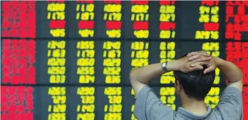  ??  ?? A Chinese investor monitors stock prices at a securities firm