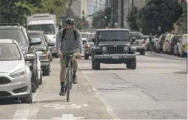  ?? ASHLEE REZIN/SUN-TIMES ?? A bicyclist rides in the bike lanes on North Milwaukee Avenue in Logan Square in 2020.