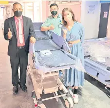  ?? ?? Dr Nanthakuma­r (le ) and his team give the thumbs-up for the contributi­on of the patient transport trolleys to Sibu Hospital by the NGO.