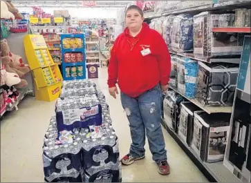  ?? Photograph­s by Jenny Jarvie For The Times ?? JESSICA ENDICOTT, a Family Dollar store manager in Warfield, Ky., says sales of bottled water have risen.