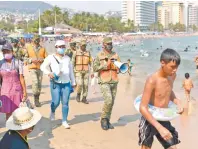  ??  ?? Militares y funcionari­os reparten un cubrebocas por palapa, y a través de un altavoz piden aplicar las medidas sanitarias.