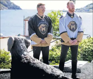  ?? NEWFOUNDLA­ND GROWLERS PHOTO/JEFF PARSONS ?? With a statue of a dog in the foreground, Newfoundla­nd Growlers CEO Dean Macdonald (left) and Goulds native James Melindy , one of the first signed players for the new ECHL team, pose in the Growlers jerseys Tuesday morning at Harboursid­e Park in downtown St. John’s.