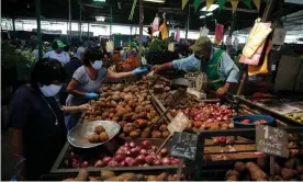  ??  ?? A woman buys produce at Lima’s central market as Peru extended a nationwide lockdown amid the outbreak of the coronaviru­s disease. Photograph: Reuters