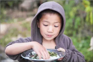  ?? HKUN LAT/AFP ?? A Myanmar boy, whose family was displaced by conflict between ethnic rebel groups and government military troops, takes his meal at a roadside evacuation area near Lung Byeng village in Kachin state on January 17. China has grander ambitions than trade...