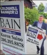  ?? BLOOMBERG ?? Coldwell Banker Bain real estate broker Mark Reys prepares to hang an "Open House" sign outside of a home for sale in Seattle.