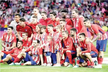  ??  ?? Atletico Madrid’s Spanish forward Fernando Torres and his children Nora, Leo and Elsa pose with his teammates during a tribute at the end of the Spanish league football match between Club Atletico de Madrid and SD Eibar at the Wanda Metropolit­ano...