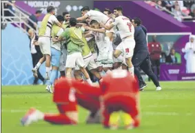  ?? Foto: AP ?? Los jugadores de Irán celebra su triunfo mientras los galeses aparecen hundidos