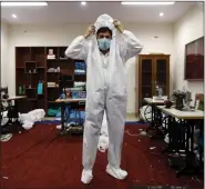  ?? REUTERS ?? A Central Reserve Police Force (CRPF) member tries a protective suit at a workshop inside a CRPF camp during a 21day nationwide lockdown to slow the spread of coronaviru­s, in New Delhi, on Friday.