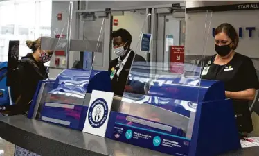  ?? Yi-Chin Lee / Staff photograph­er ?? United Airlines customer-service representa­tives help passengers at the boarding gate at George Bush Interconti­nental Airport. Flight attendants suggest arriving an hour or two earlier than normal.