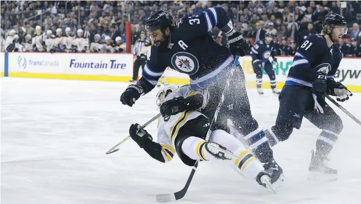  ?? — POSTMEDIA NEWS ?? Winnipeg Jets defenceman Dustin Byfuglien runs over Boston Bruins forward Tommy Wingels in Winnipeg on Tuesday.