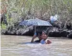  ??  ?? UNA mujer y su hija se protegen del sol con una sombrilla