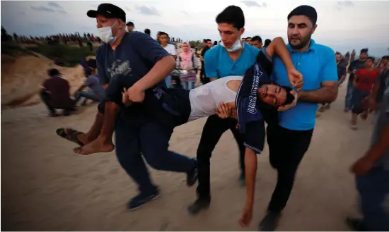  ??  ?? A wounded Palestinia­n is evacuated during a protest in the northern Gaza Strip calling for lifting the Israeli blockade on Gaza.