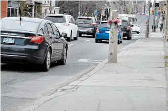  ?? JOHN RENNISON THE HAMILTON SPECTATOR ?? Scrapes in the sidewalk lead to a light pole with marks where a car struck a DARTS driver who was dropping off a passenger on Main Street Thursday. The driver died from her injuries.