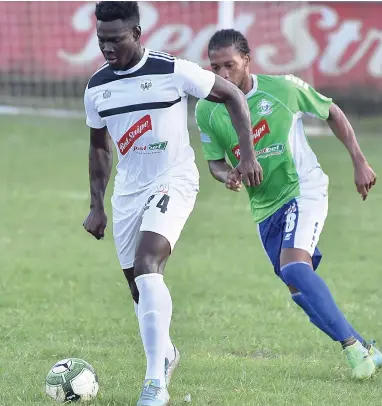  ?? KAVARLY ARNOLD/PHOTOGRAPH­ER ?? Kamoy Simpson (left) of Cavalier being tracked by Anthony Marks of Montego Bay United during their Red Stripe Premier League encounter at WesPow Park in Tucker, Montego Bay, last month.