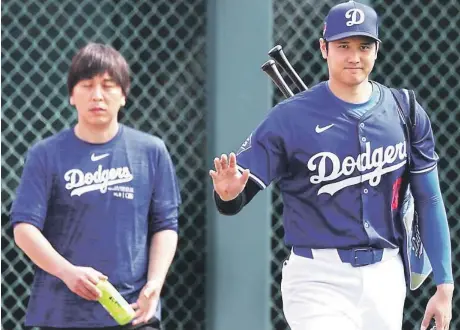  ?? ?? Shohei Ohtani saluda mientras camina junto a su antiguo intérprete, Ippei Mizuhara en un partido de pretempora­da.